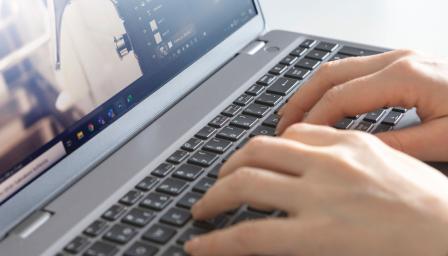 Henkilö työskentelee kannettavalla tietokoneella.