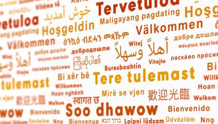 Seinä, jossa eri kielillä sana "Tervetuloa".