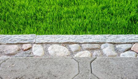 Pihakivetyksen koristereunus ja nurmea lähikuvassa.