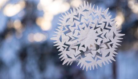 Paperinen lumihiutalekoriste ikkunassa.