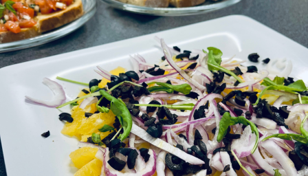 Ruokapöytä, jossa lautasilla ruoka-annoksia.