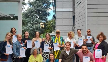 Yhteiskuva kurssin osallistujista, jotka pitävät käsissään kurssitodistuksiaan.