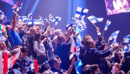 Suomen lippuja heilutetaan katsomossa.