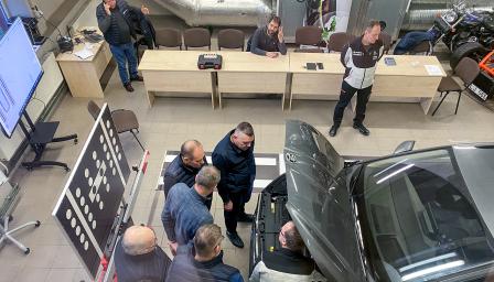 Henkilöitä korjaamassa autoa.