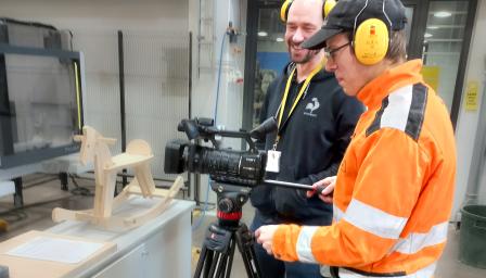 Kaksi henkilöä työstämässä CNC-moduulia.