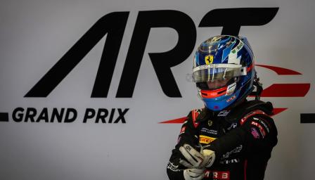Kilpa-ajaja Tuukka Taponen seisoo ajovarusteissa ART Grand Prix -tallin varikolla, Ferrari Driver Academy -logo näkyy kypärässä.