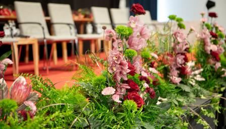 Kukkia lavan edustalla. Takana näkyy rivi tuoleja.