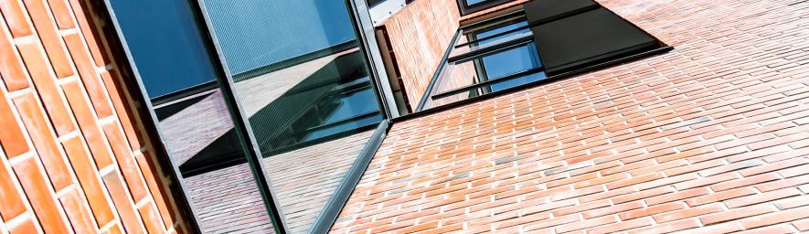 Rakennuken tiiliseinä ja ikkunoita kuvattun viistosti alhaaltapäin.