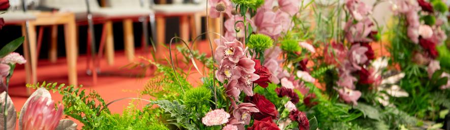 Kukkia lavan edustalla. Takana näkyy rivi tuoleja.