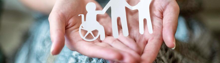  Paperista leikattuja ihmishahmoja henkilön kämmenellä.