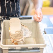 Taidepajan opiskelija leikkaa savipalaa.