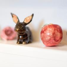 Pieniä keraamisia teoksia hyllyllä.