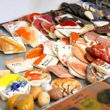 Eri muotoisia keramiikkapaloja, jotka on maalattu eri väreillä ja joihin on kirjoitettu värin koodi.