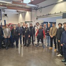 Ryhmäkuva Auto CoVE 2.0 -hankkeen työpajasta Ranskassa. Kuvassa on opettajia ja opiskelijoita poseeraamassa korjaamoympäristössä auton ja hankkeen roll-upin edessä.