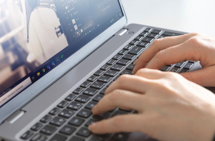 Henkilö työskentelee kannettavalla tietokoneella.