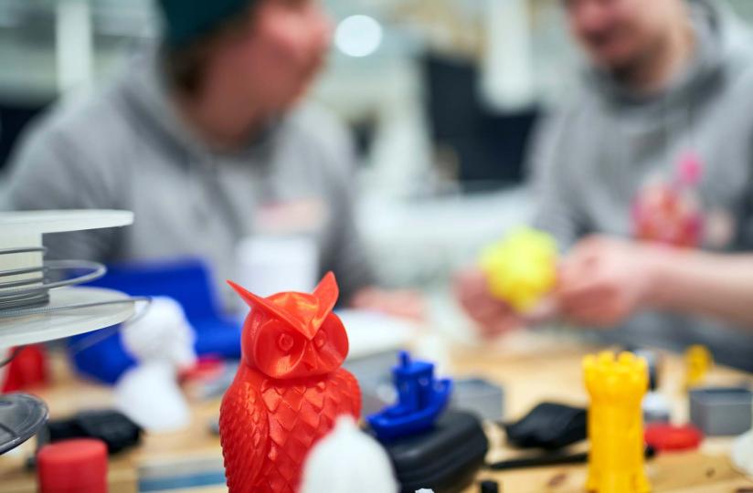 Yrittäjät katsovat pöydällä olevia 3D-tulosteita.