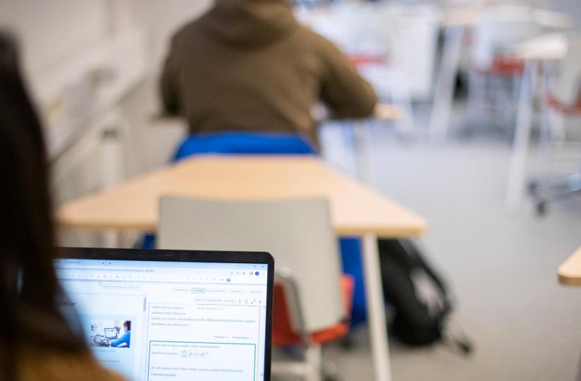 Lukio-opiskelijoita luokassa tietokoneella.