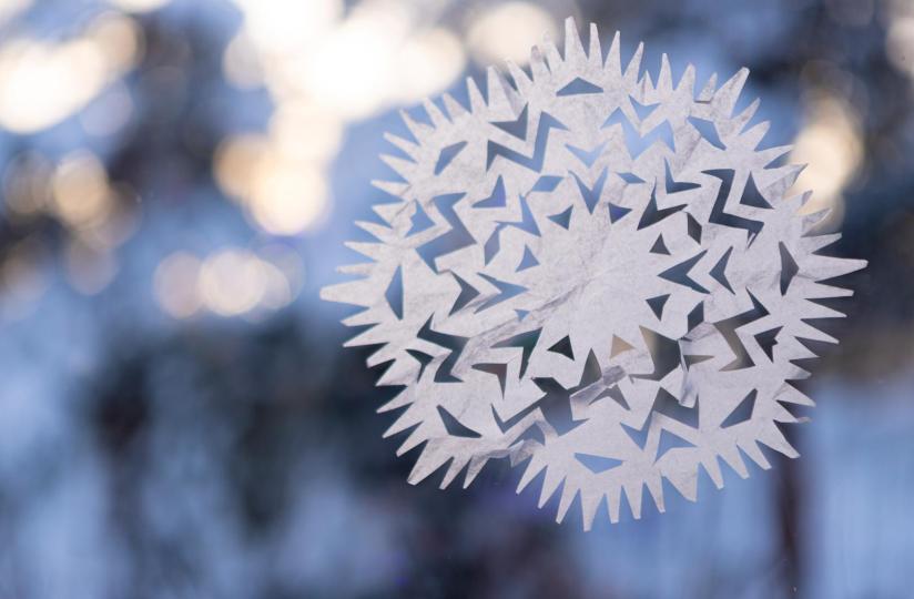 Paperinen lumihiutalekoriste ikkunassa.