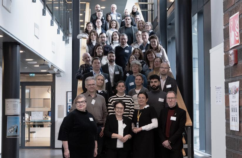 Joukko ihmisiä seisoo portaissa.