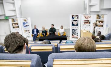 Auditorion ylätasanteelta otetussa kuvassa näkyy neljä ehdokasta ja kaksi haastattelijaa sekä Omnian roll-upit.