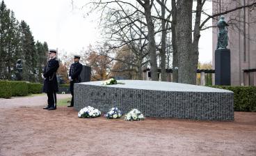 Hautamuistomerkki Autuas, jonka vieressä seisoo kaksi kadettia.