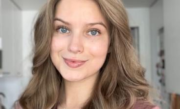 Annika Mattila katsoo kameraan ja hymyilee.