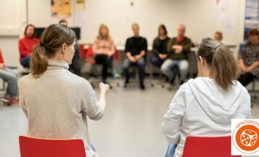 Ihmiset ringissä keskustelemassa työväenopiston tunnilla