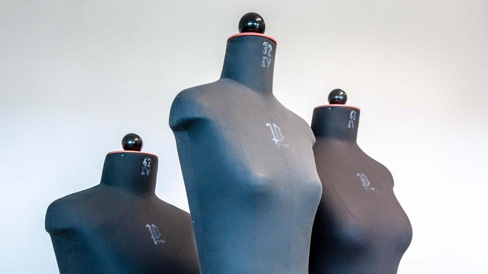 Kolme sovitusnukkea vaatetusosastolta.