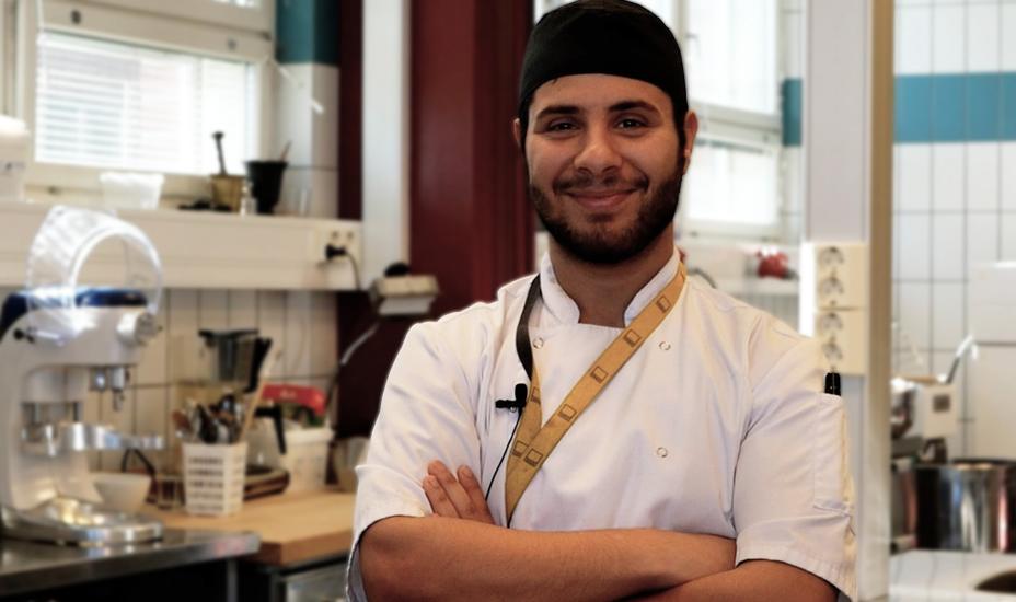 Ahmed Hussein katsoo kameraa leipuritakki ja huivi päällään.