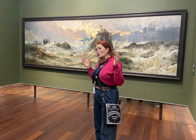 Taidehistorian luennoitsija Liisa Väisänen taideteoksen edessä.