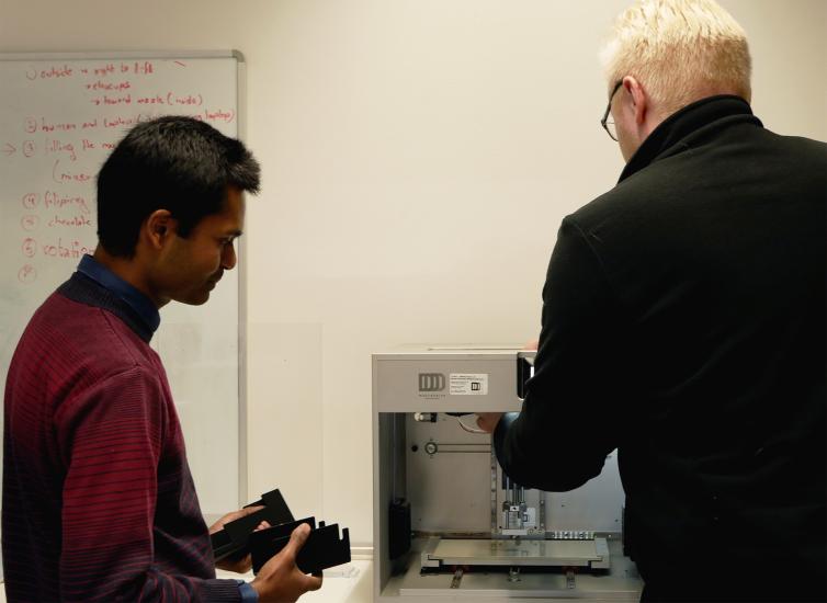Santosh Mehta ja Petri Heino asettavat osia paikalleen 3D-tulostimeen.