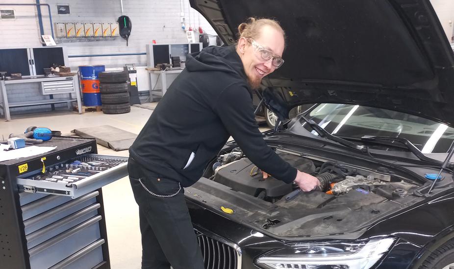 Jan Borg seisoo auton edessä, jonka konepelti on nostettu ylös. 