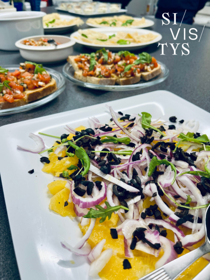 Ruokapöytä, jossa lautasilla ruoka-annoksia.