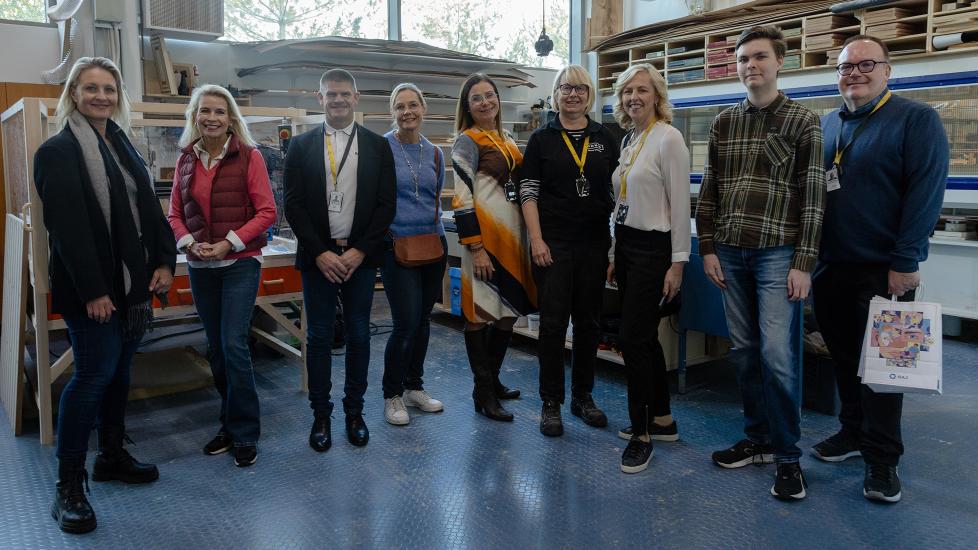 Vierailulle osallistuneet henkilöt seisovat ryhmäkuvassa.