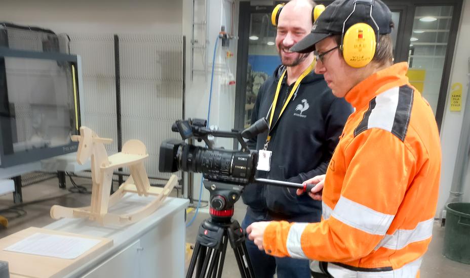 Kaksi henkilöä työstämässä CNC-moduulia.