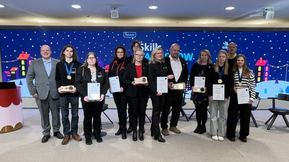 Kuvassa 12 palkinnon vastaanottanutta ihmistä.