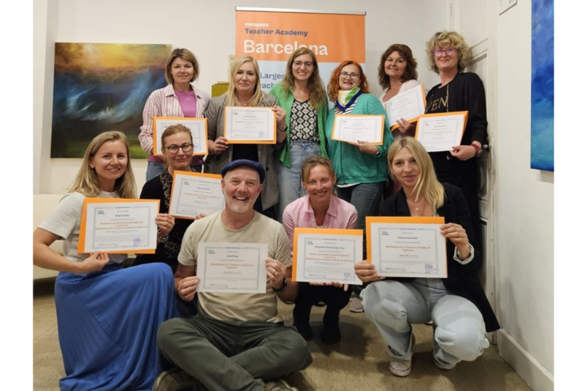 Ryhmä kurssin osallistujia poseeraa todistusten kanssa Teacher Academy Barcelonan tiloissa.